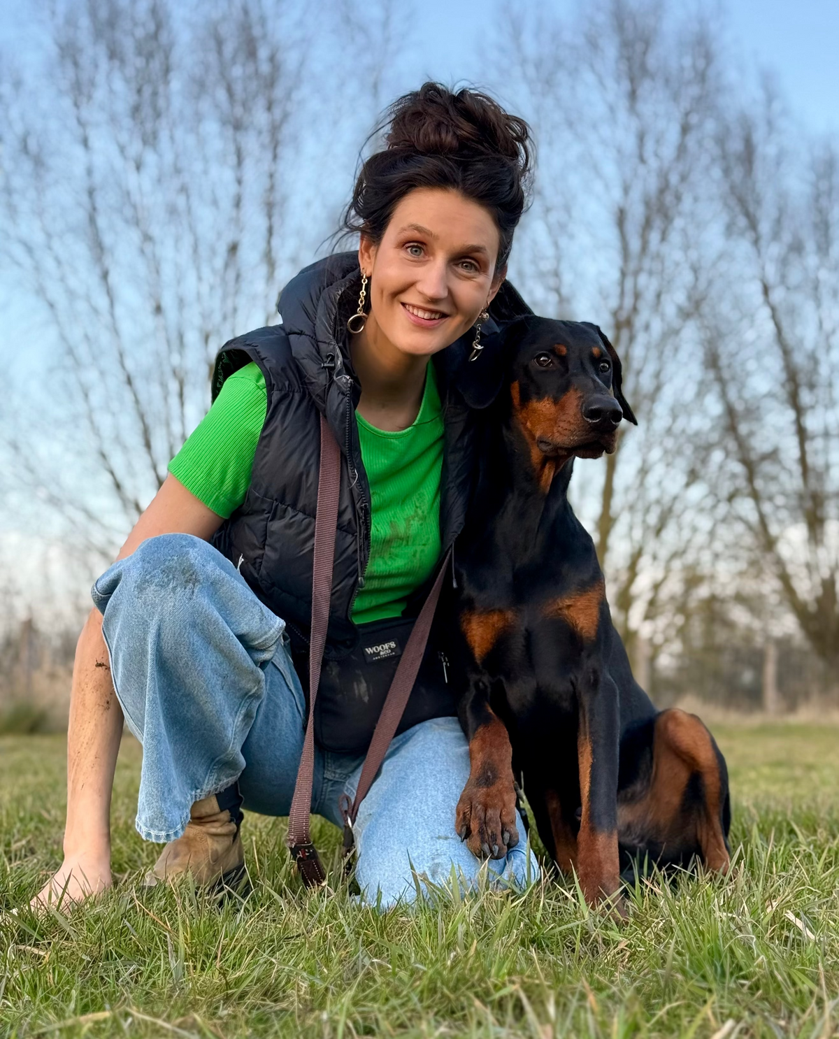 Woman with a dog sitting on grass outdoors